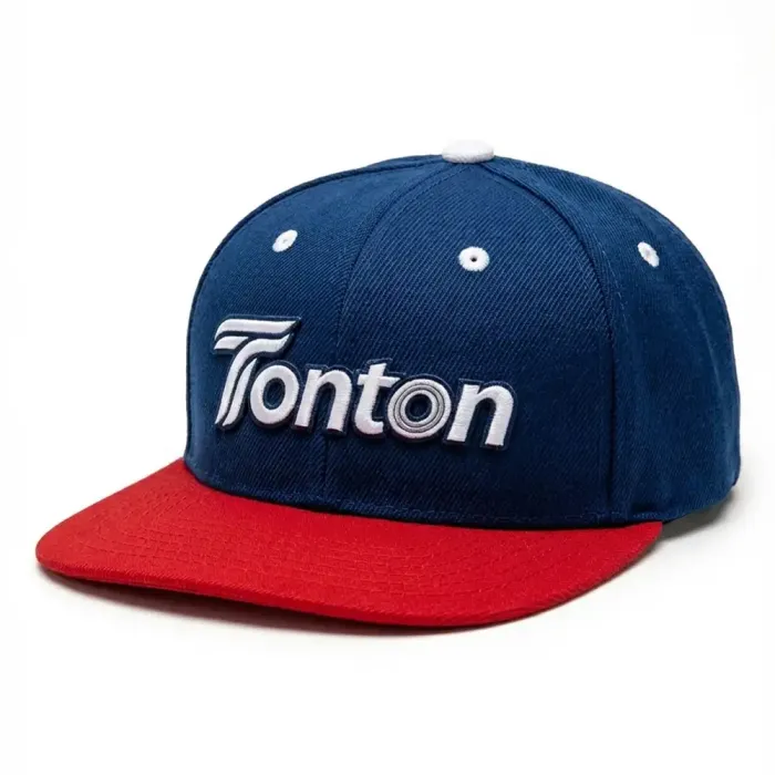 Front view of tonton custom dark blue snapback cap with a contrast red flat brim and silver 3D embroidered logo.